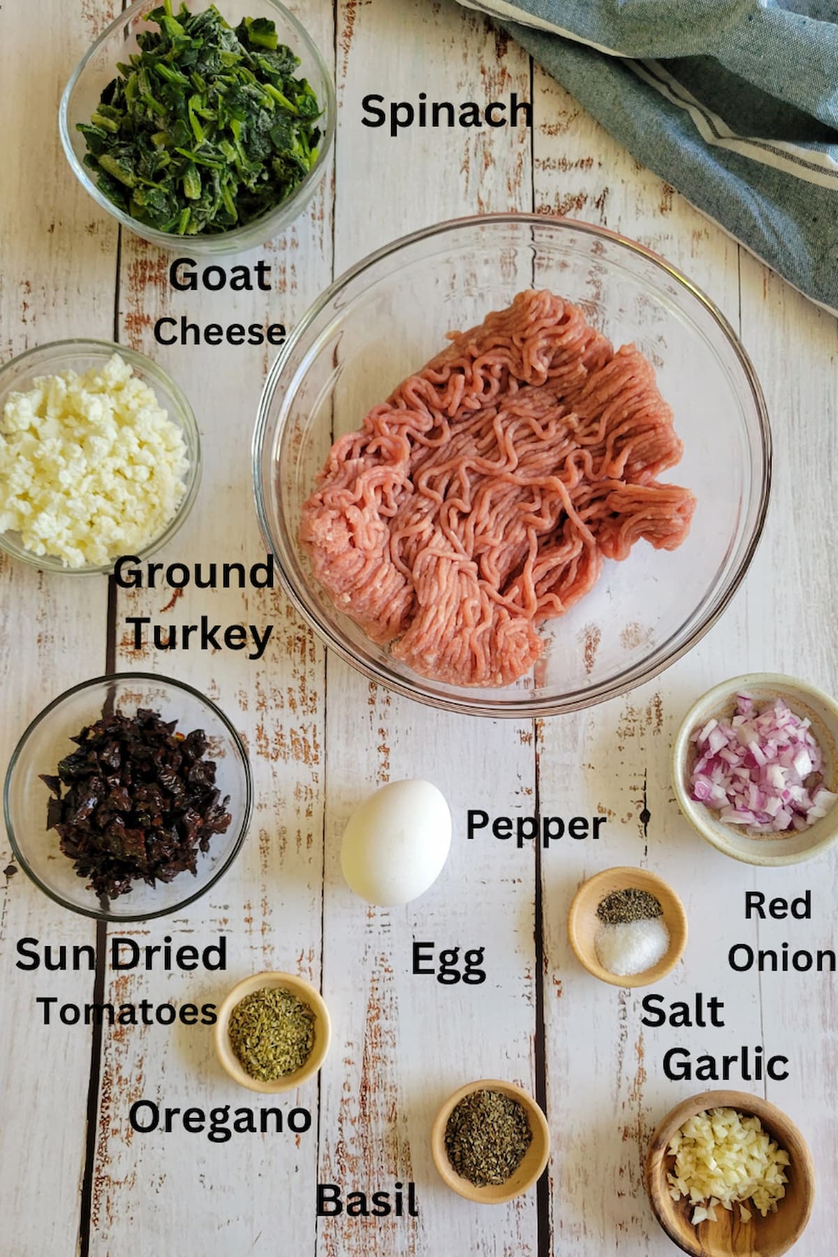 ingredients for recipe for turkey meatballs - ground turkey, sun dried tomatoes, spinach, goat cheese, red onion, egg, garlic, salt, pepper, basil, oregano