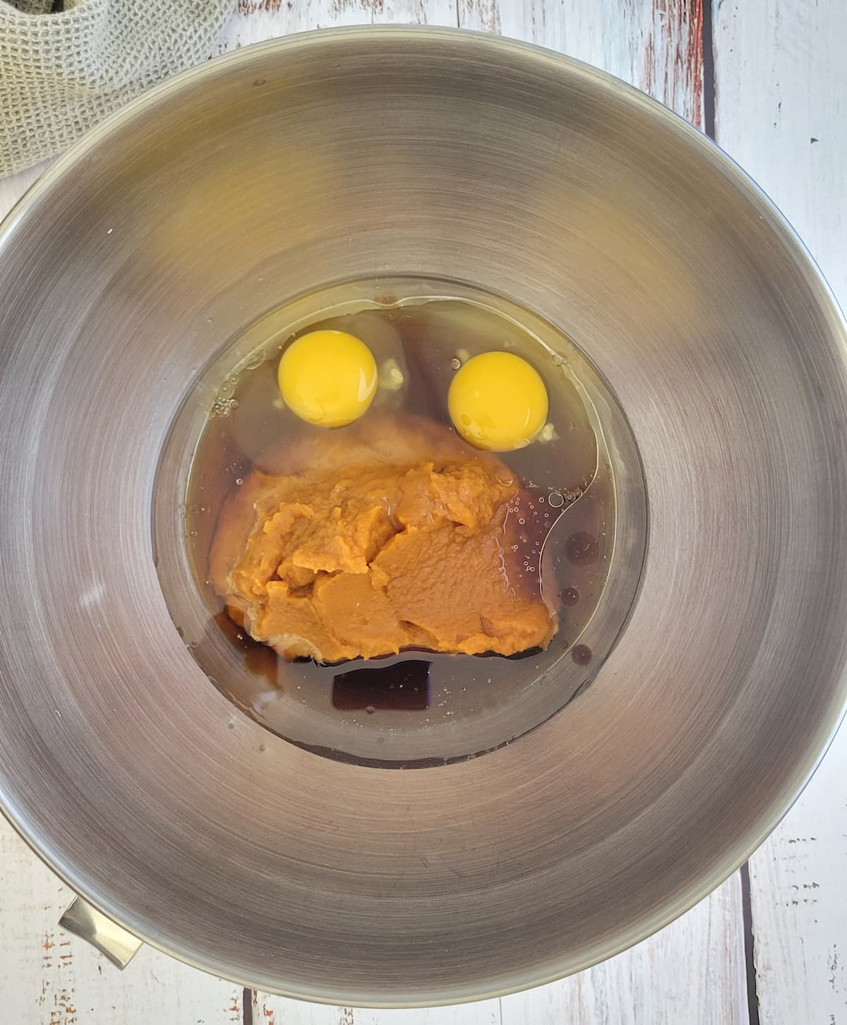 2 eggs, pumpkin puree and other wet ingredients unmixed in a bowl