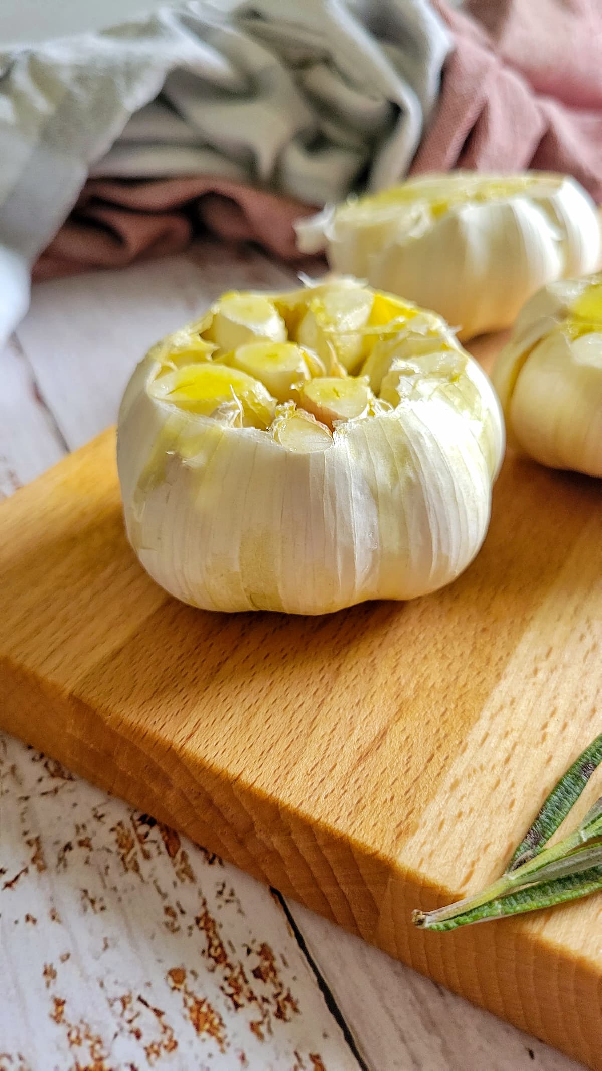 whole sliced raw garlic drizzled with oil on a cutting board