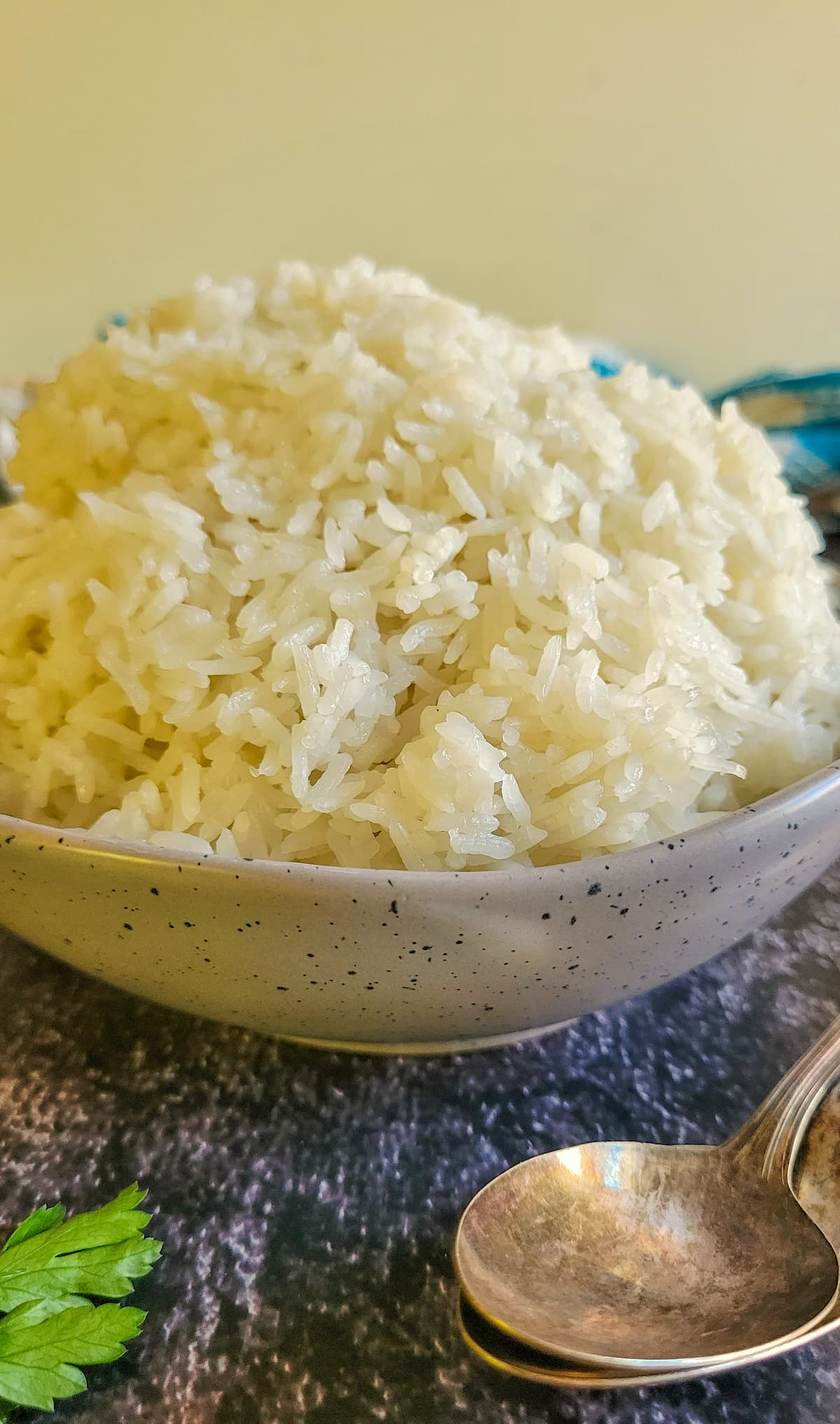 pile of white rice in a bowl, two spoons on the side