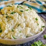 bowl of white rice garnished with chopped fresh parsley