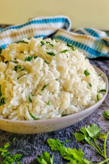 bowl of white rice garnished with chopped fresh parsley