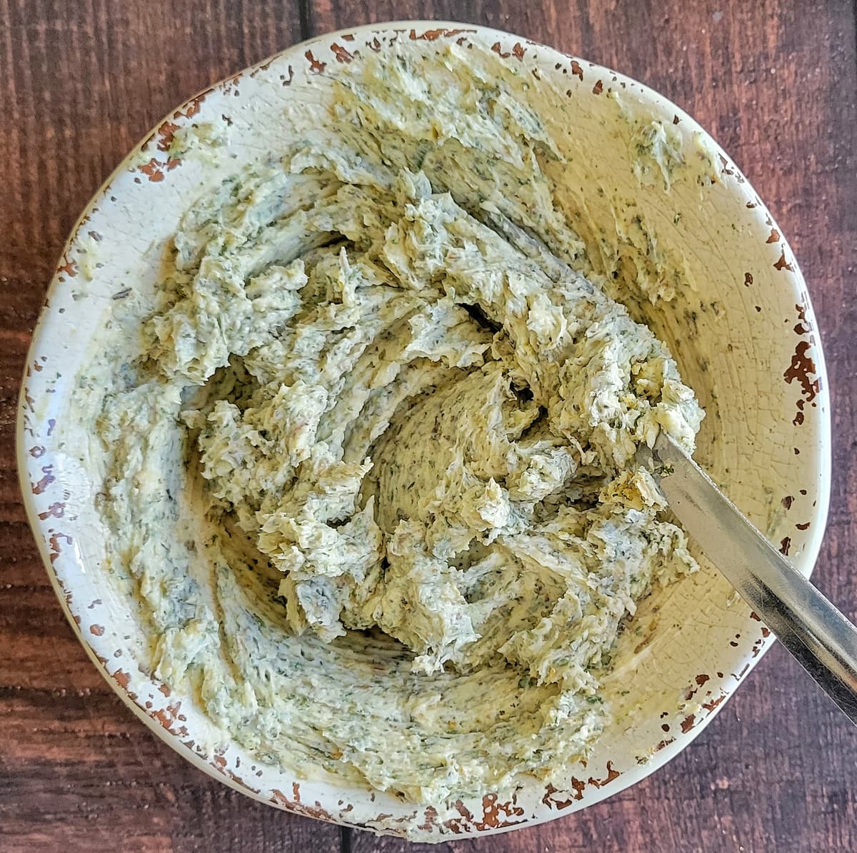 whipped garlic herb butter in a bowl with a fork