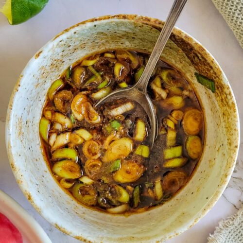 spoon in a bowl with green onions and soy sauce