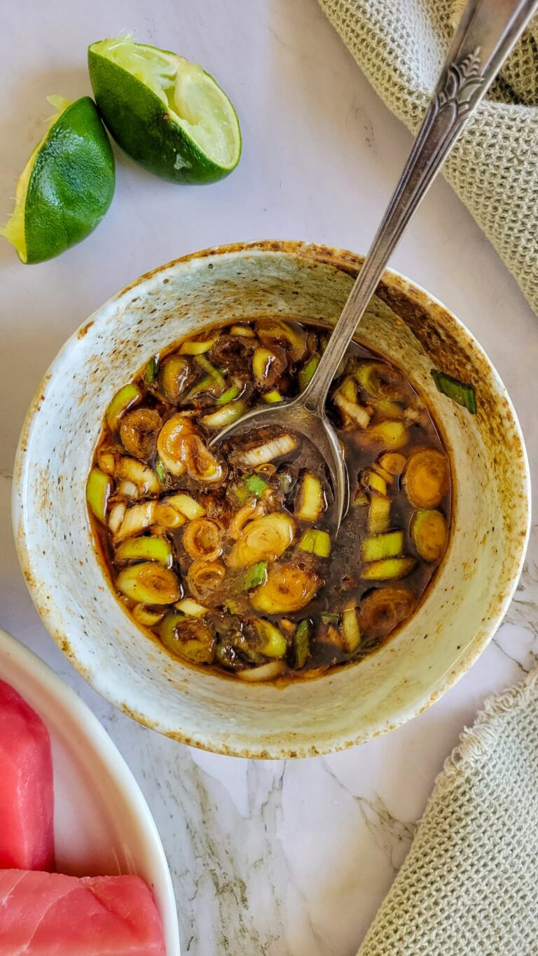 spoon in a bowl with green onions and soy sauce