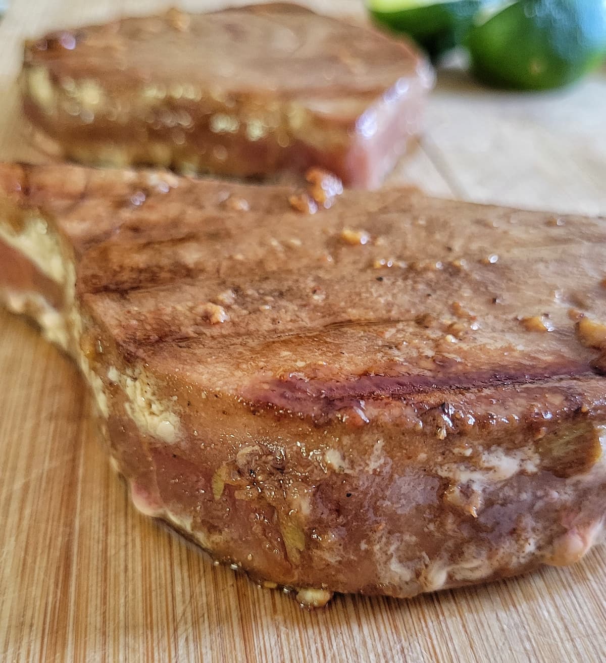 two grilled tuna steaks on a cutting board