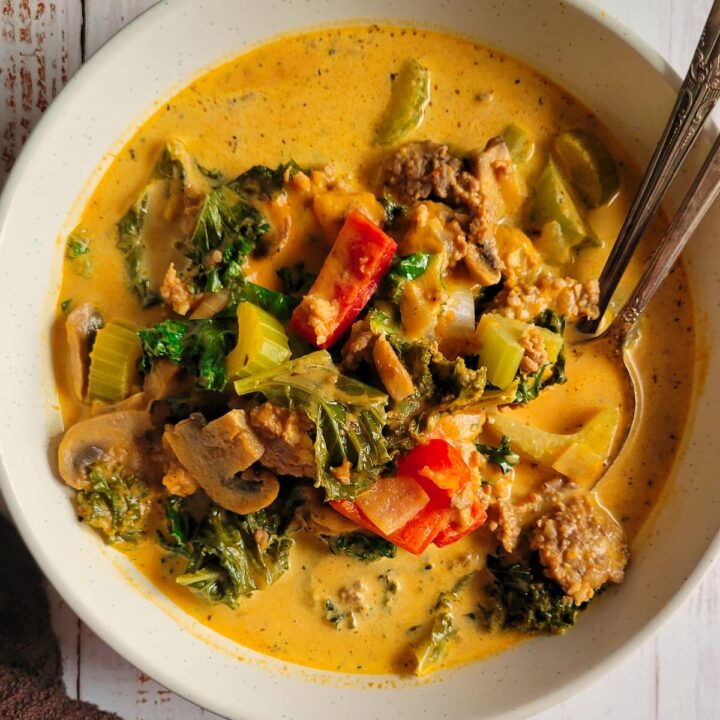 bowl of pumpkin sausage soup with kale, red bell peppers, mushrooms and celery