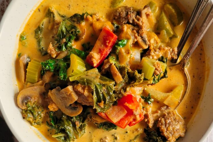 bowl of pumpkin sausage soup with kale, red bell peppers, mushrooms and celery