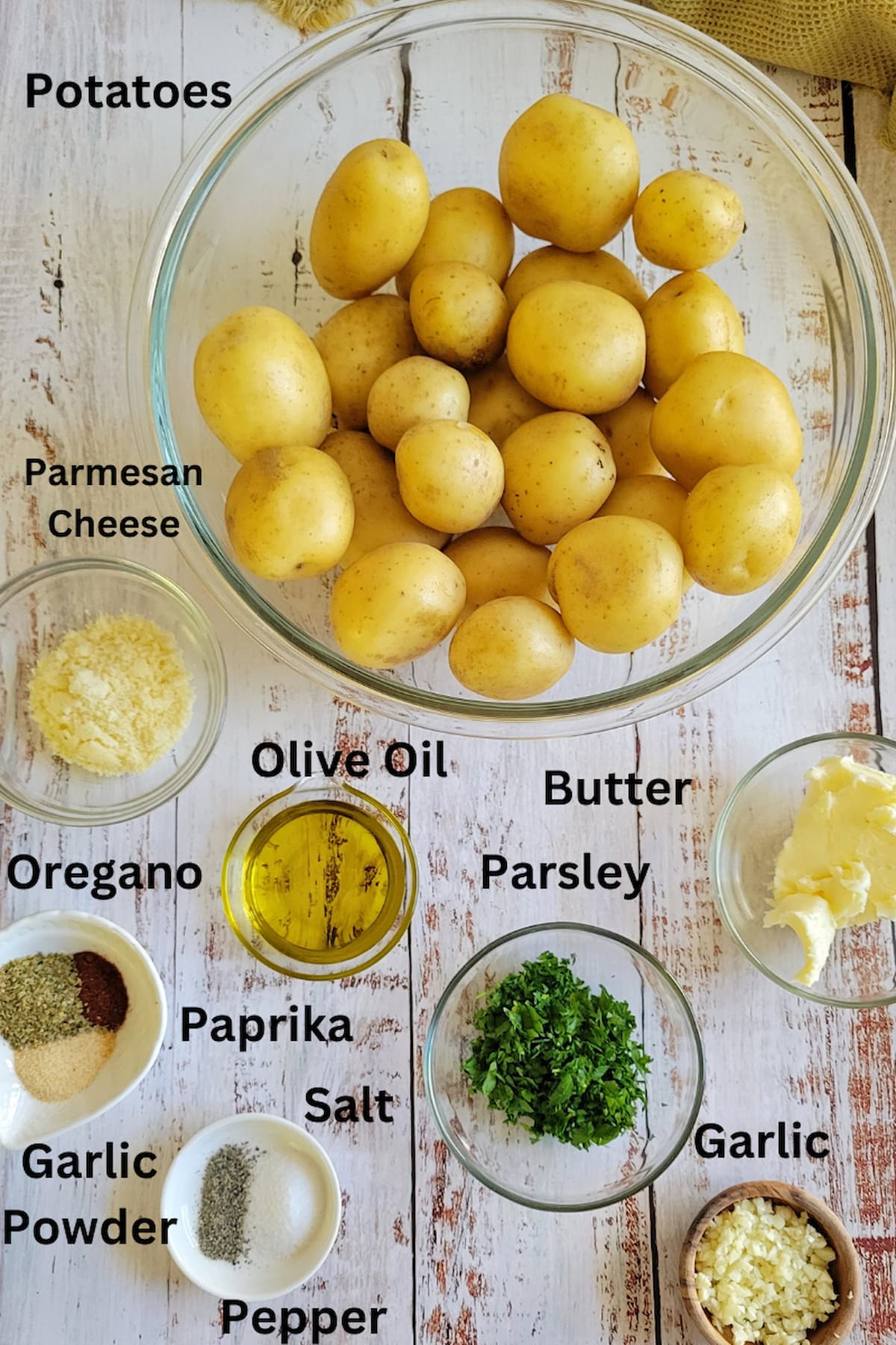 ingredients for smash potatoes in oven - potatoes, olive oil, butter, parsley, garlic, salt, pepper, paprika, garlic powder, parmesan cheese