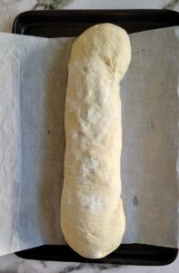 unbaked swiss chard roll on a parchment lined baking sheet