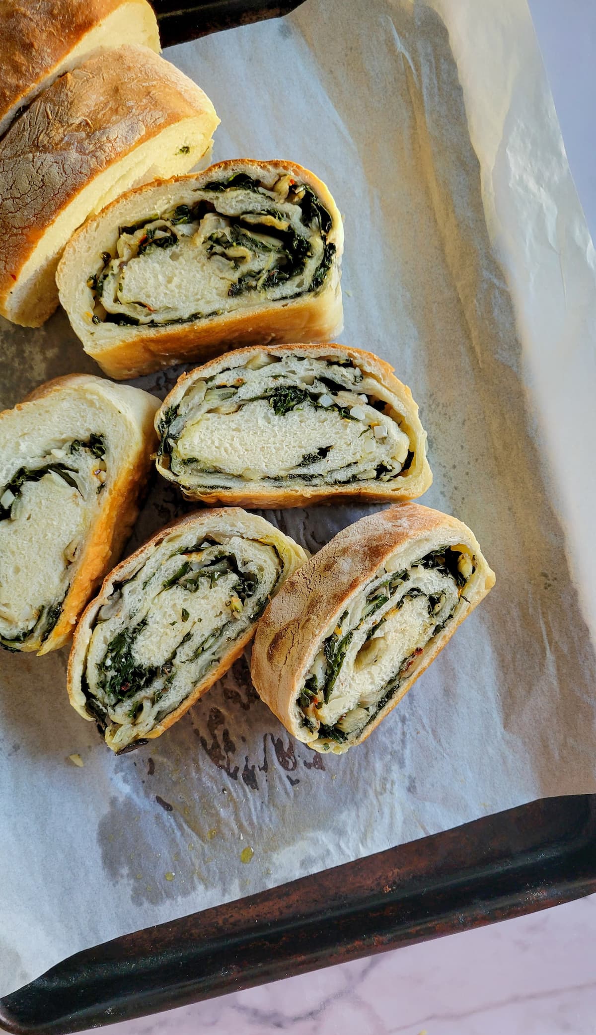 sliced swiss chard roll on a parchment lined baking sheet