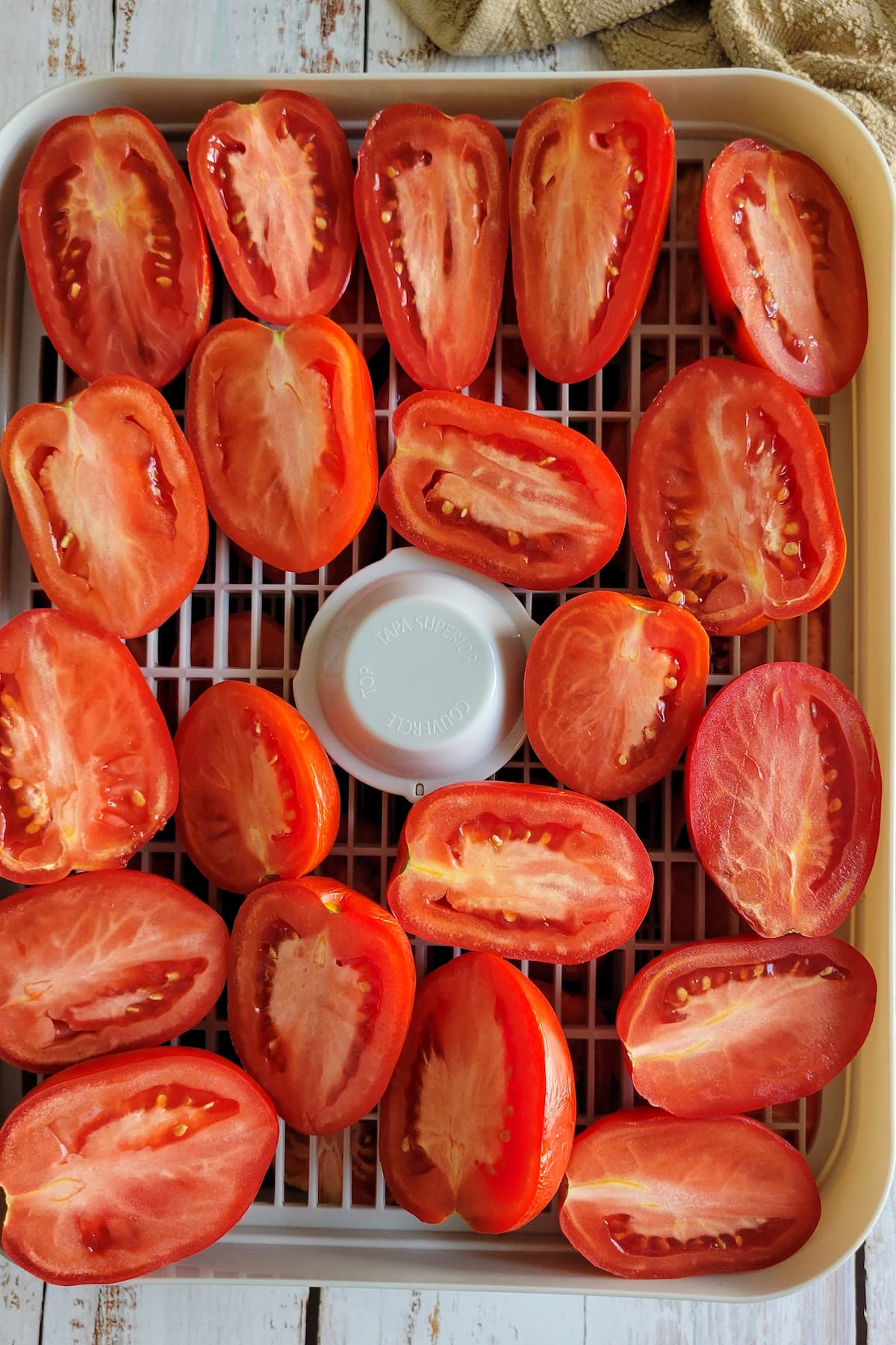 halved tomatoes on a dehydrator tray