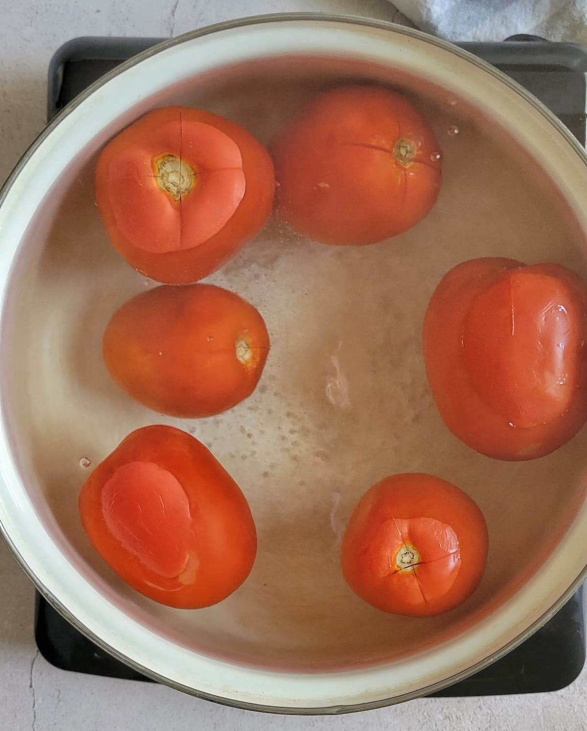 6 whole tomatoes in a pot with water