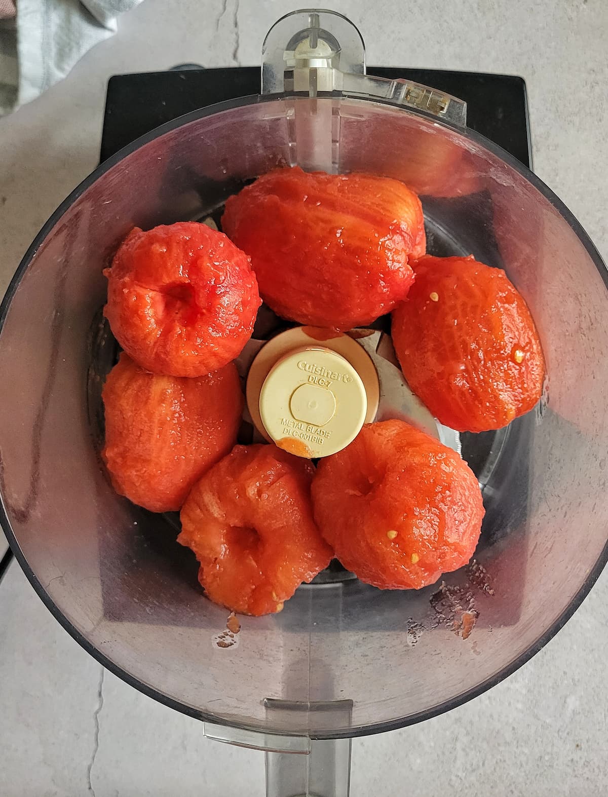whole, peeled and cored tomatoes in the body of a food processor