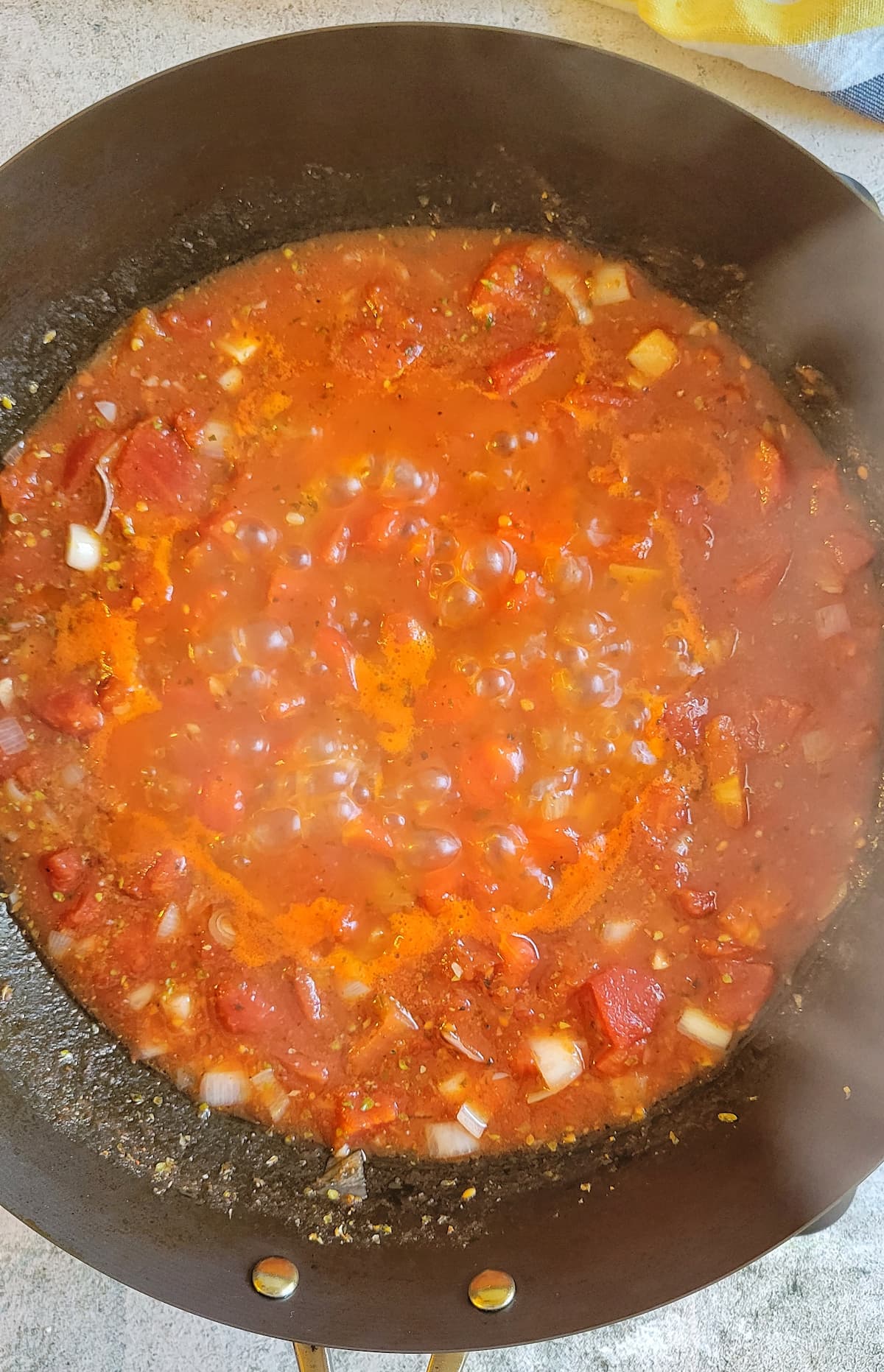 diced tomatoes and shallots simmering in a wok