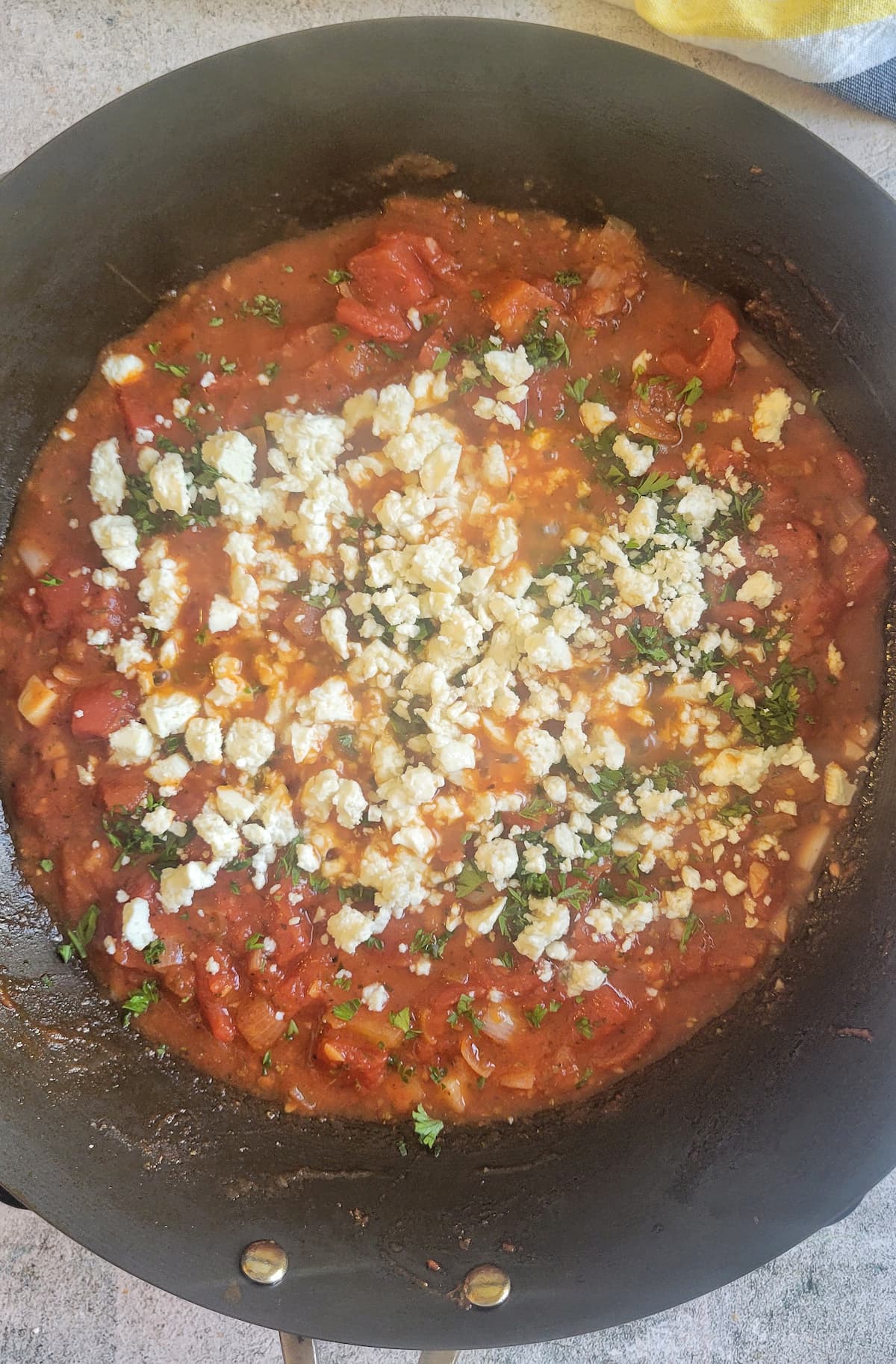 tomato sauce, fresh herbs and feta cheese in a wok