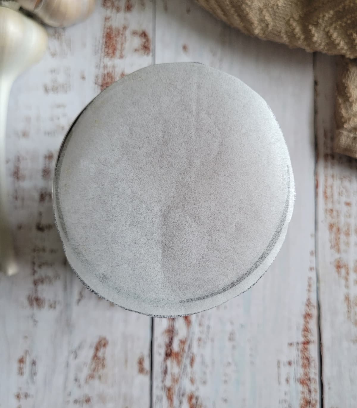 a piece of circle parchment paper over the mouth of a mason jar
