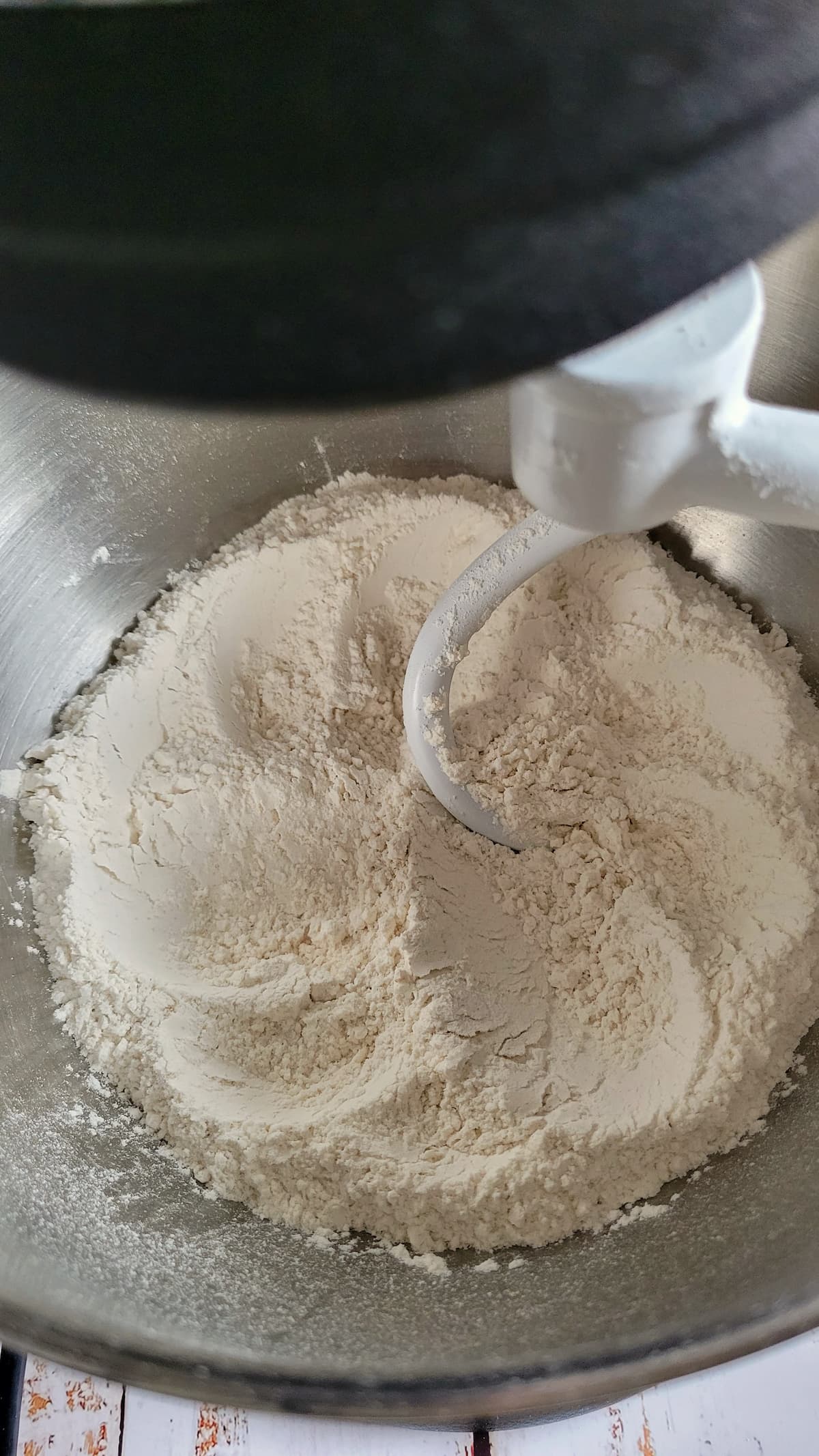 flour being mixed in a bowl of a kitchenaid stand mixer