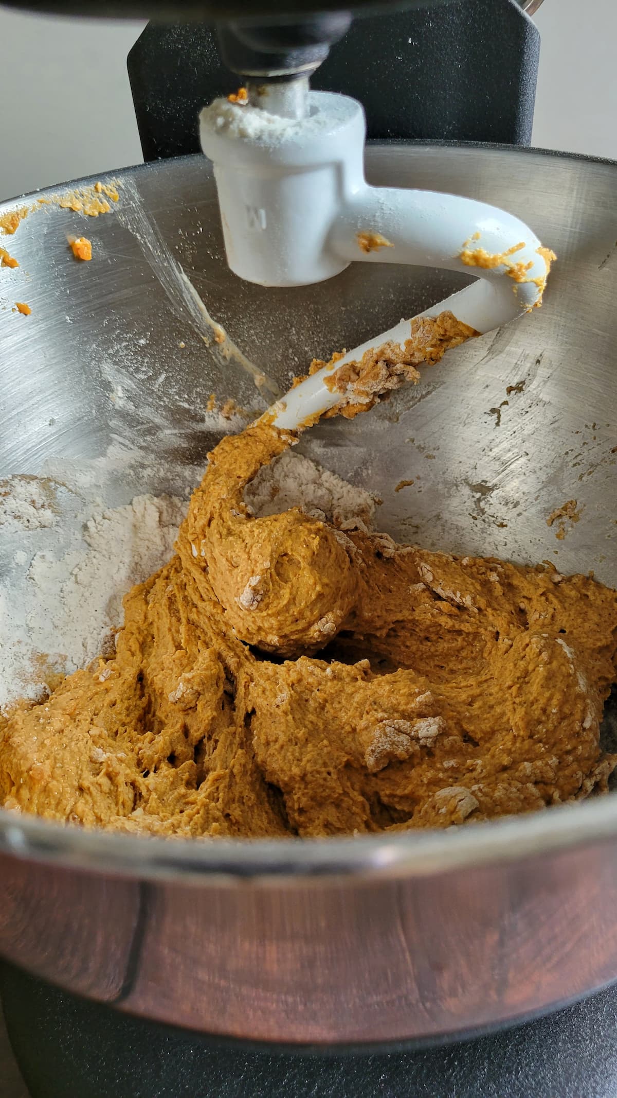 orange batter in a bowl with a dough hook