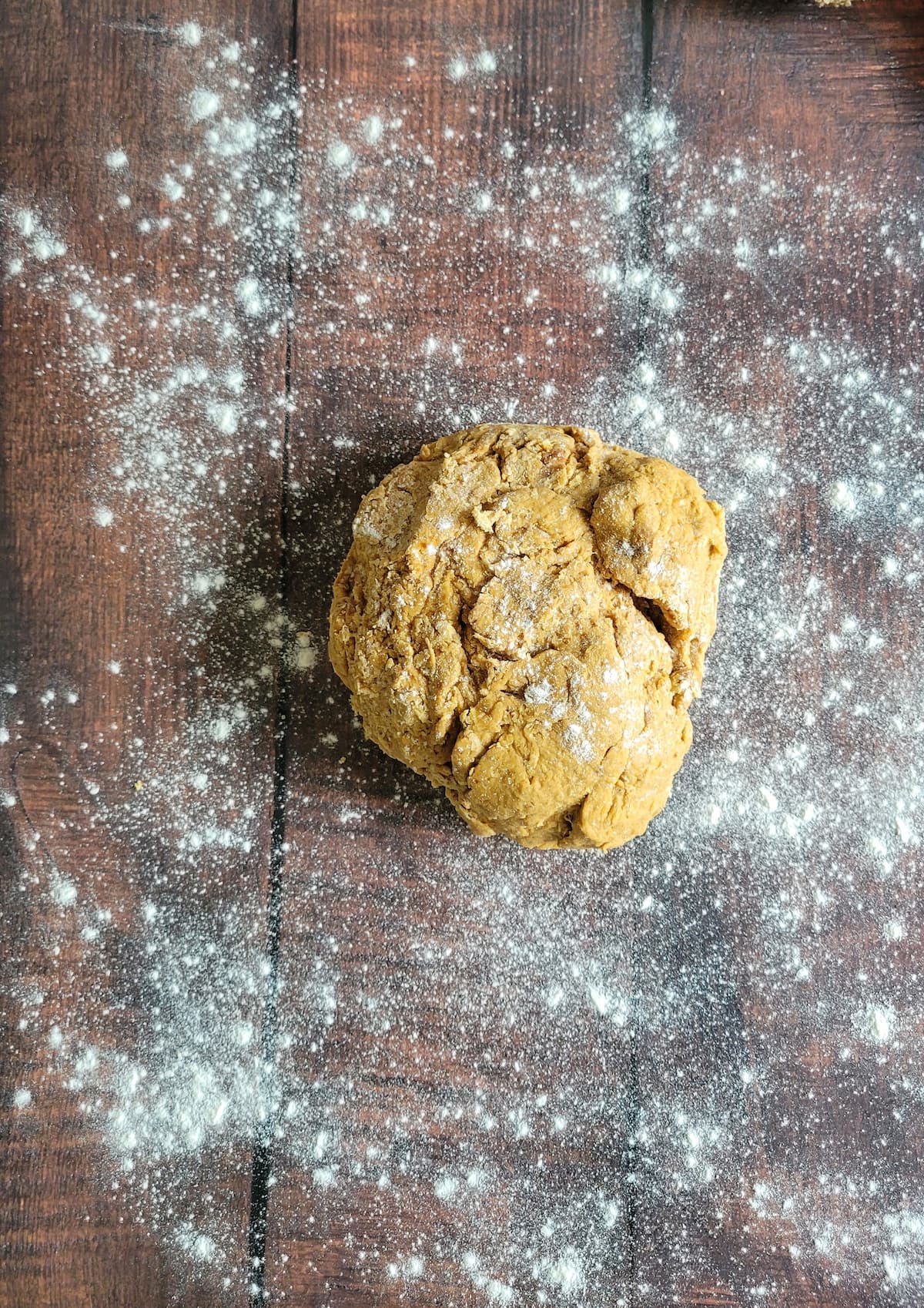 ball of orange dough on a floured surface