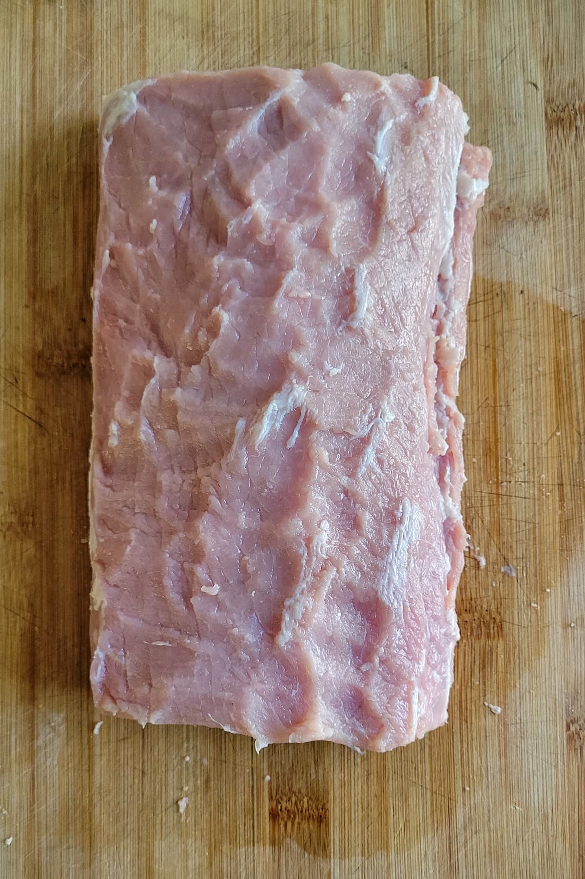 raw pork loin roast on a cutting board
