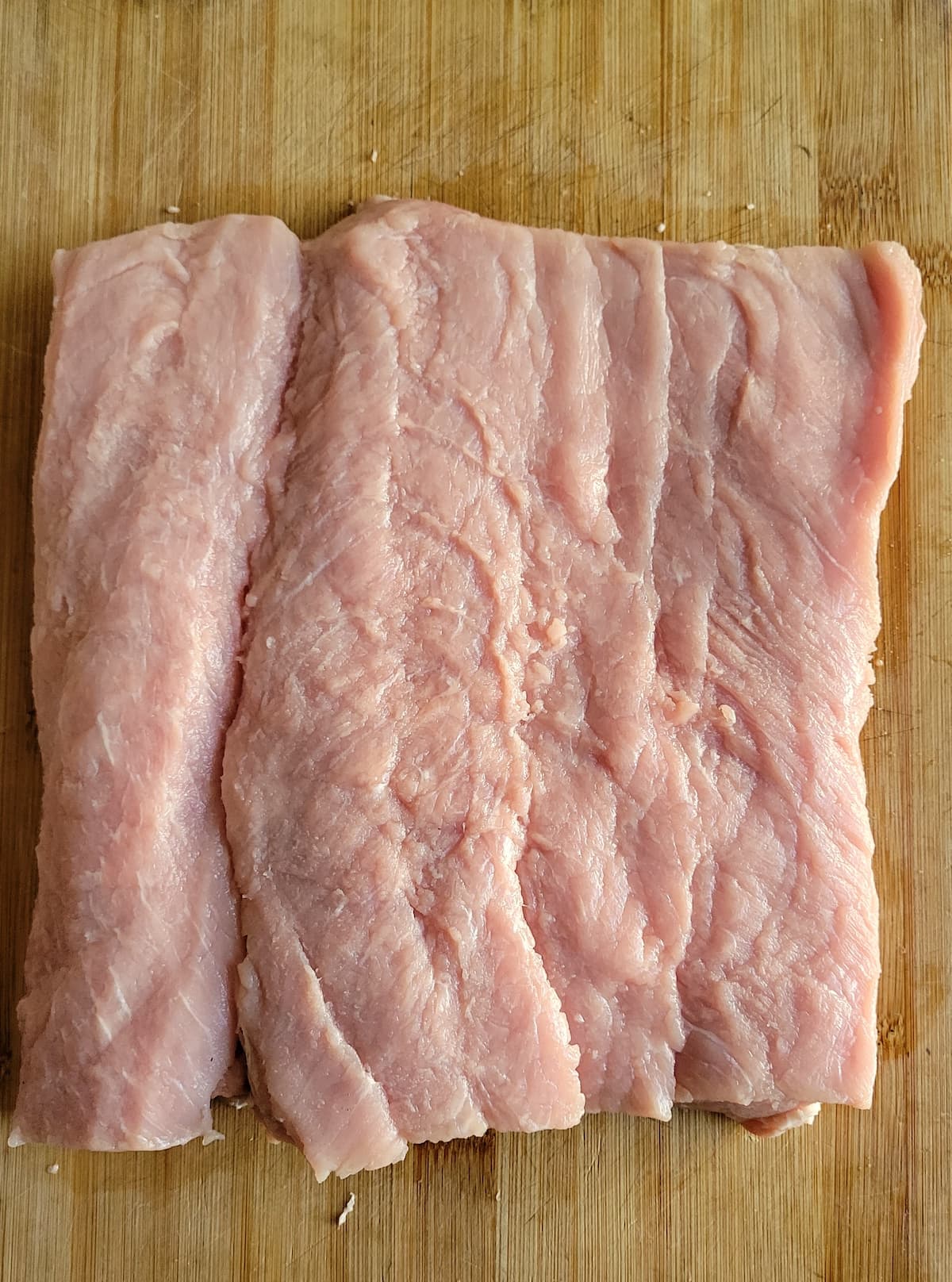 flattened out piece of pork on a cutting board