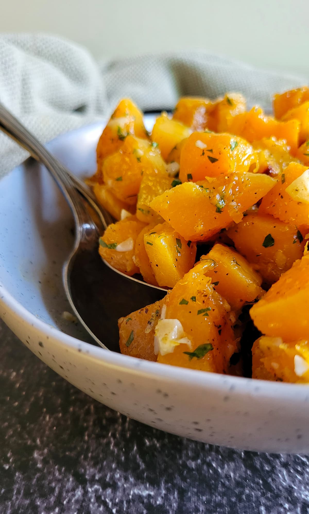 bowl of roasted butternut squash, two spoons in the bowl