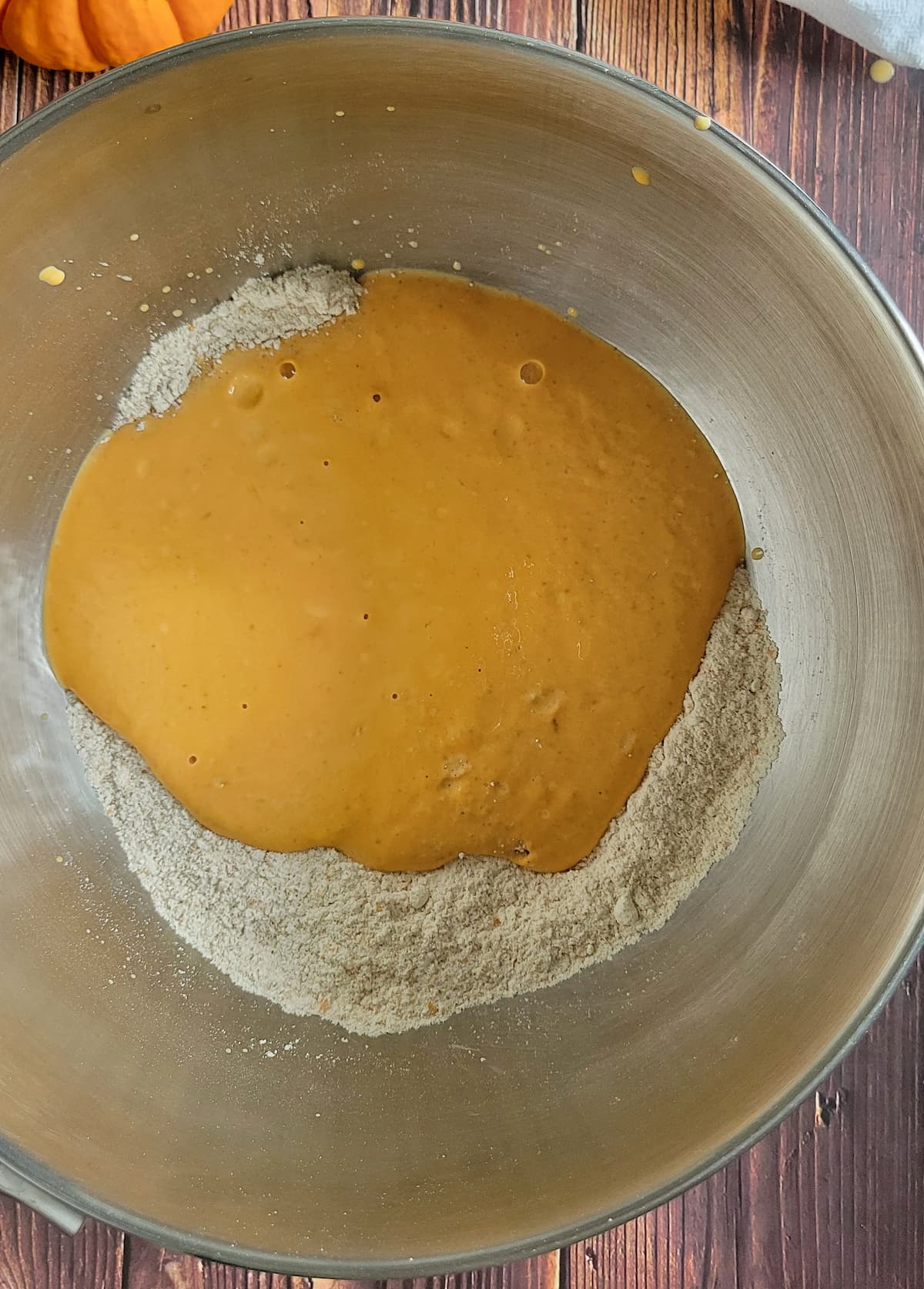 orange batter on top of flour in a bowl