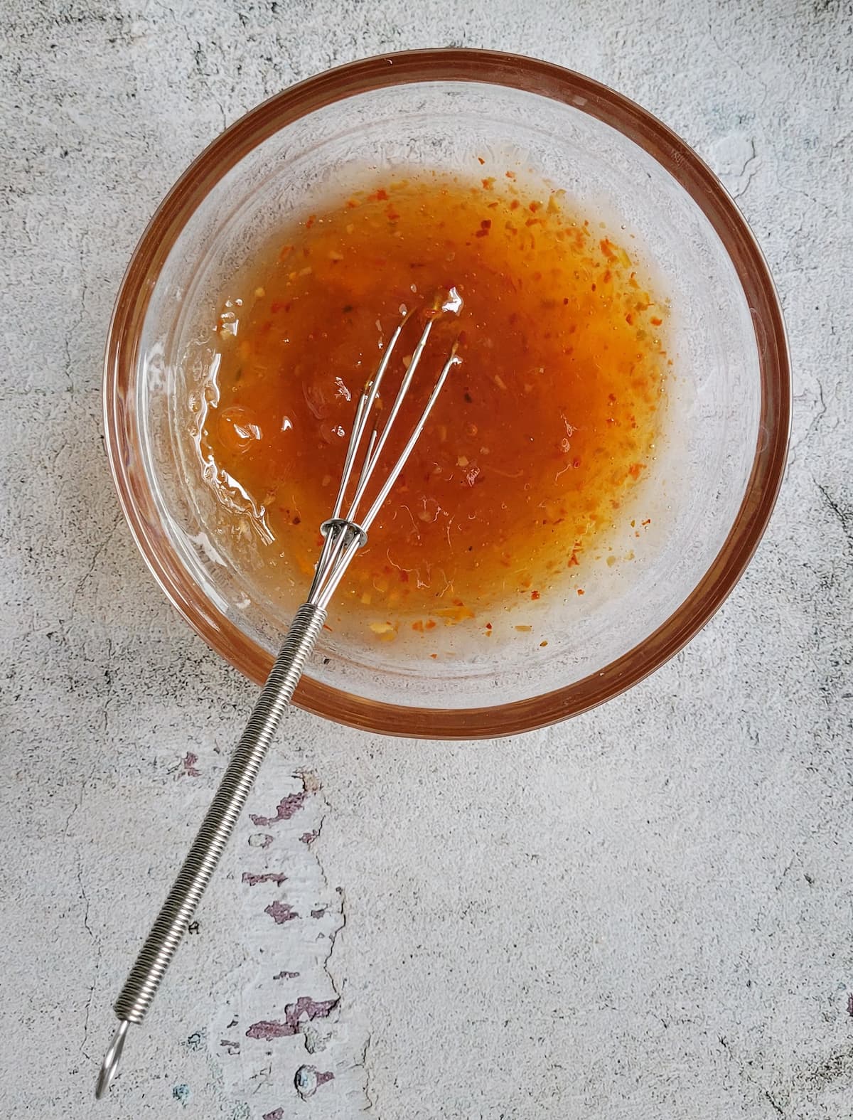 orange sauce in a bowl with a little whisk