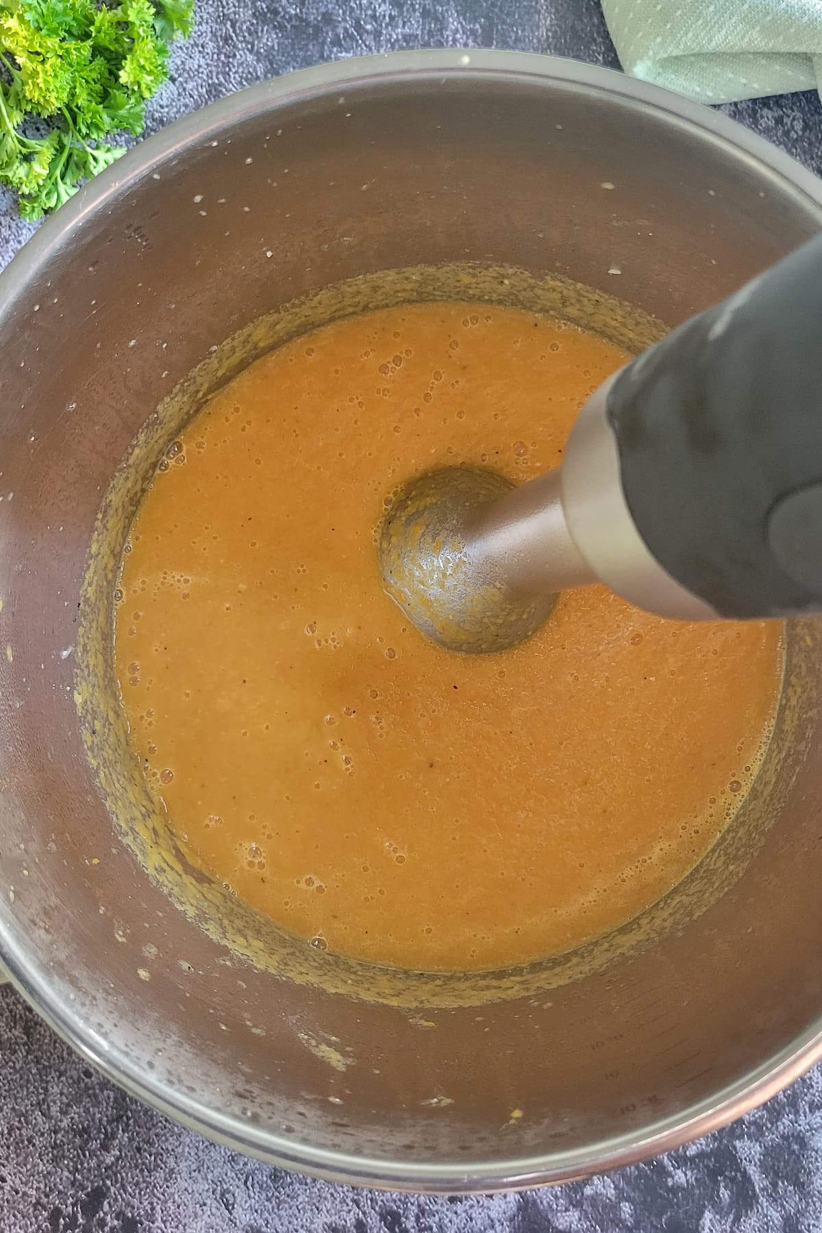 immersion blender in a pot of orange soup