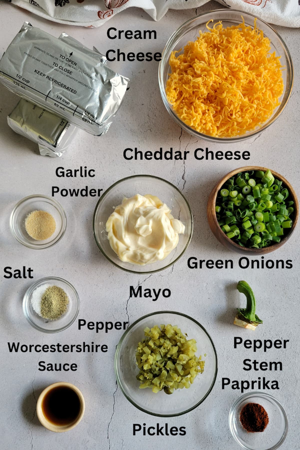 ingredients for pumpkin cheeseball - cream cheese, cheddar cheese, pickles, green onions, worcestershire sauce, paprika, garlic powder, salt, pepper, mayo, pepper stem