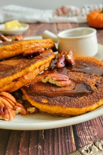 pancakes, syrup and pecans on a plate
