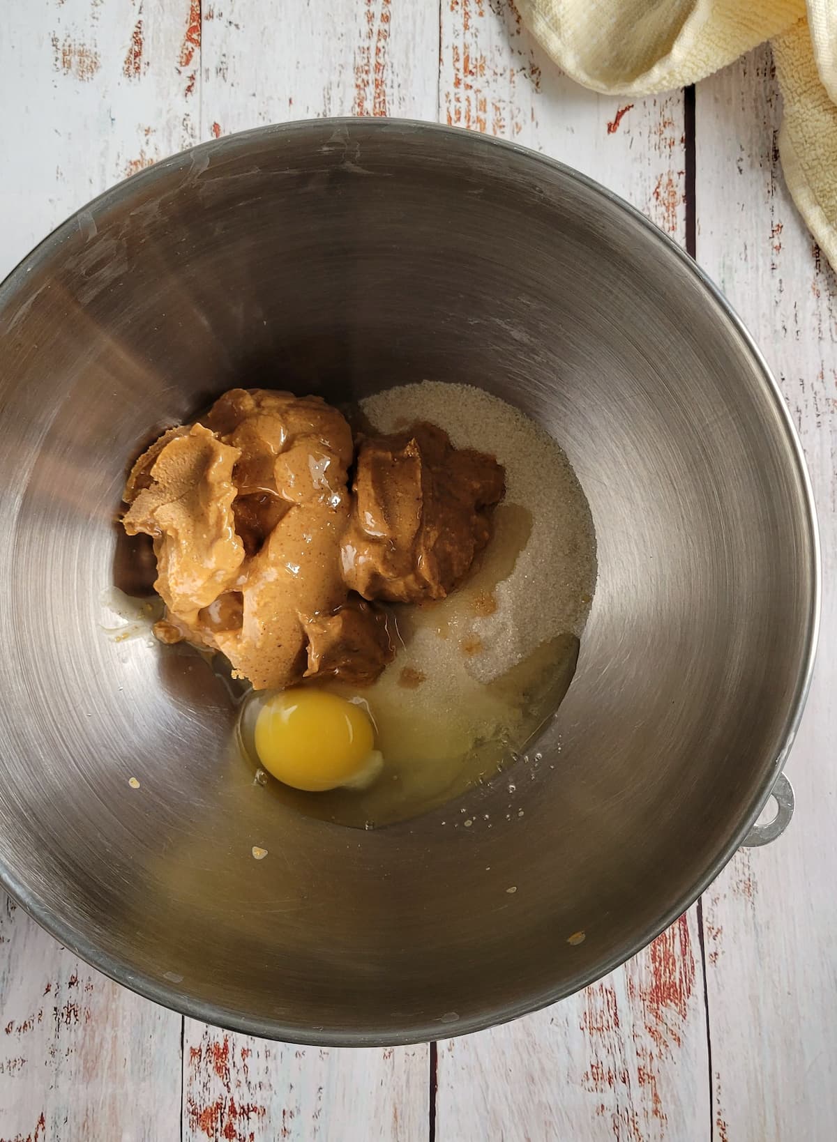peanut butter, egg and sugar unmixed in a bowl