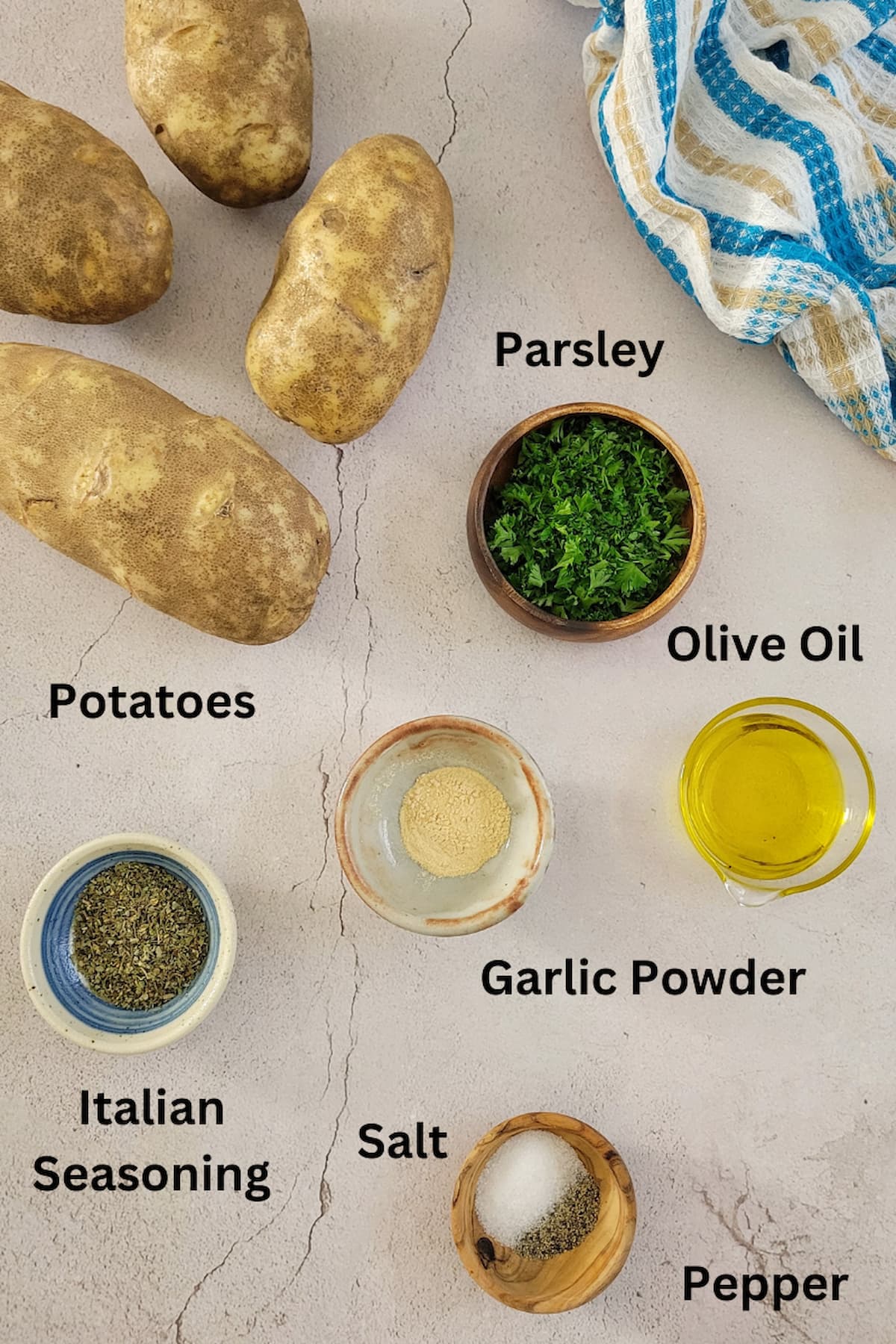 ingredients for homemade home fries in oven - potatoes, parsley, olive oil, italian seasoning, garlic powder, salt, pepper