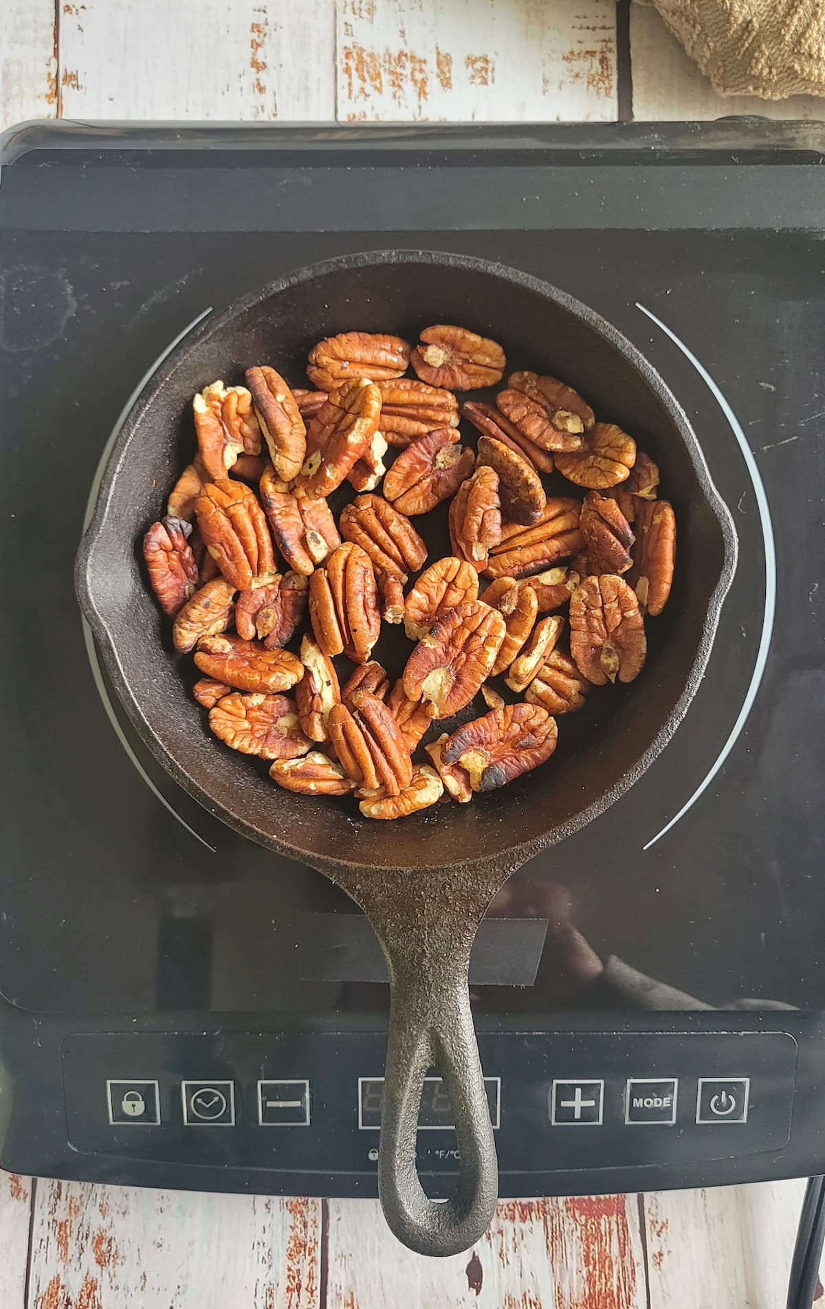 toasted pecans in a small skillet on a burner