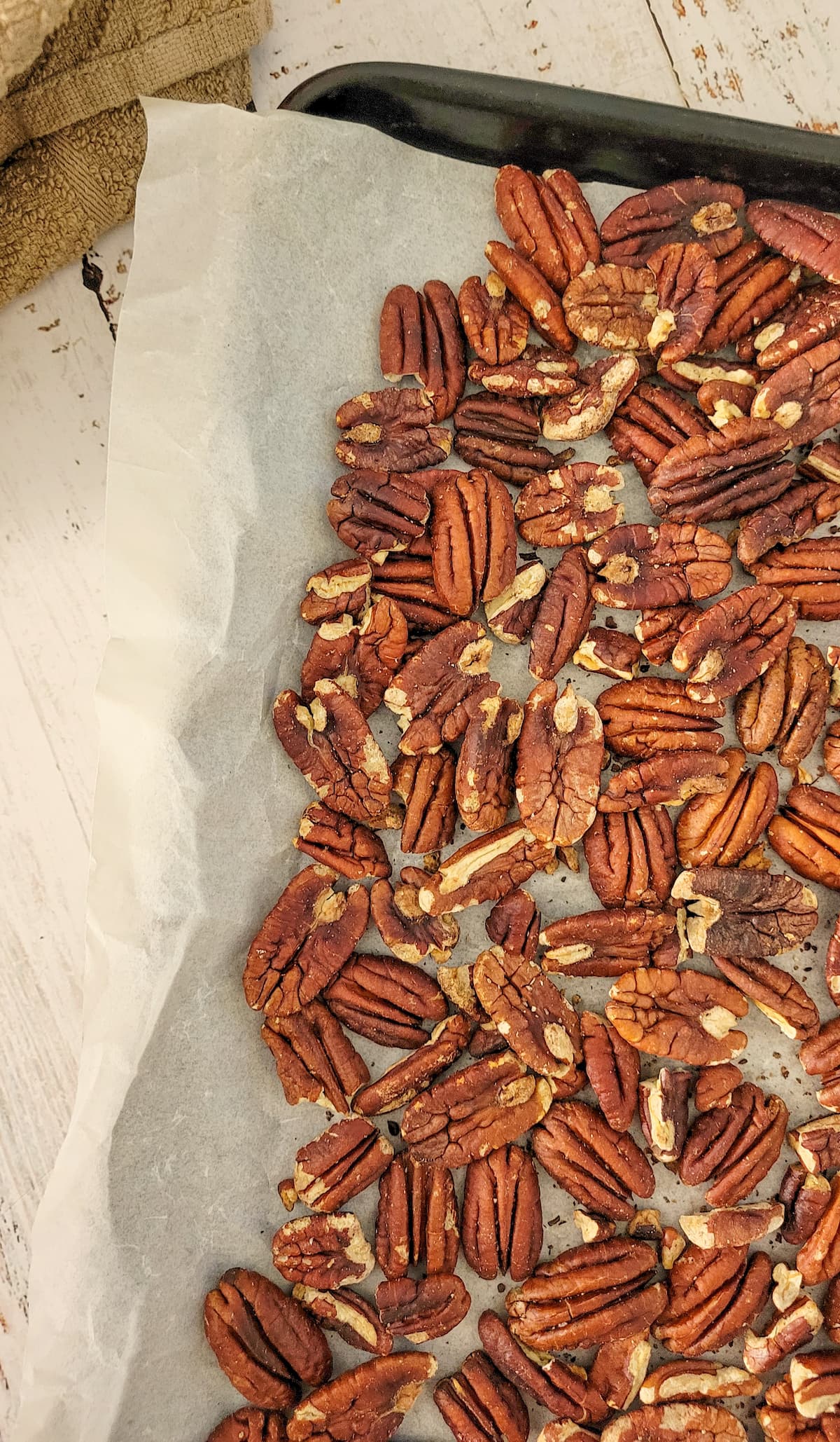 toasted pecans on a parchment lined baking sheet