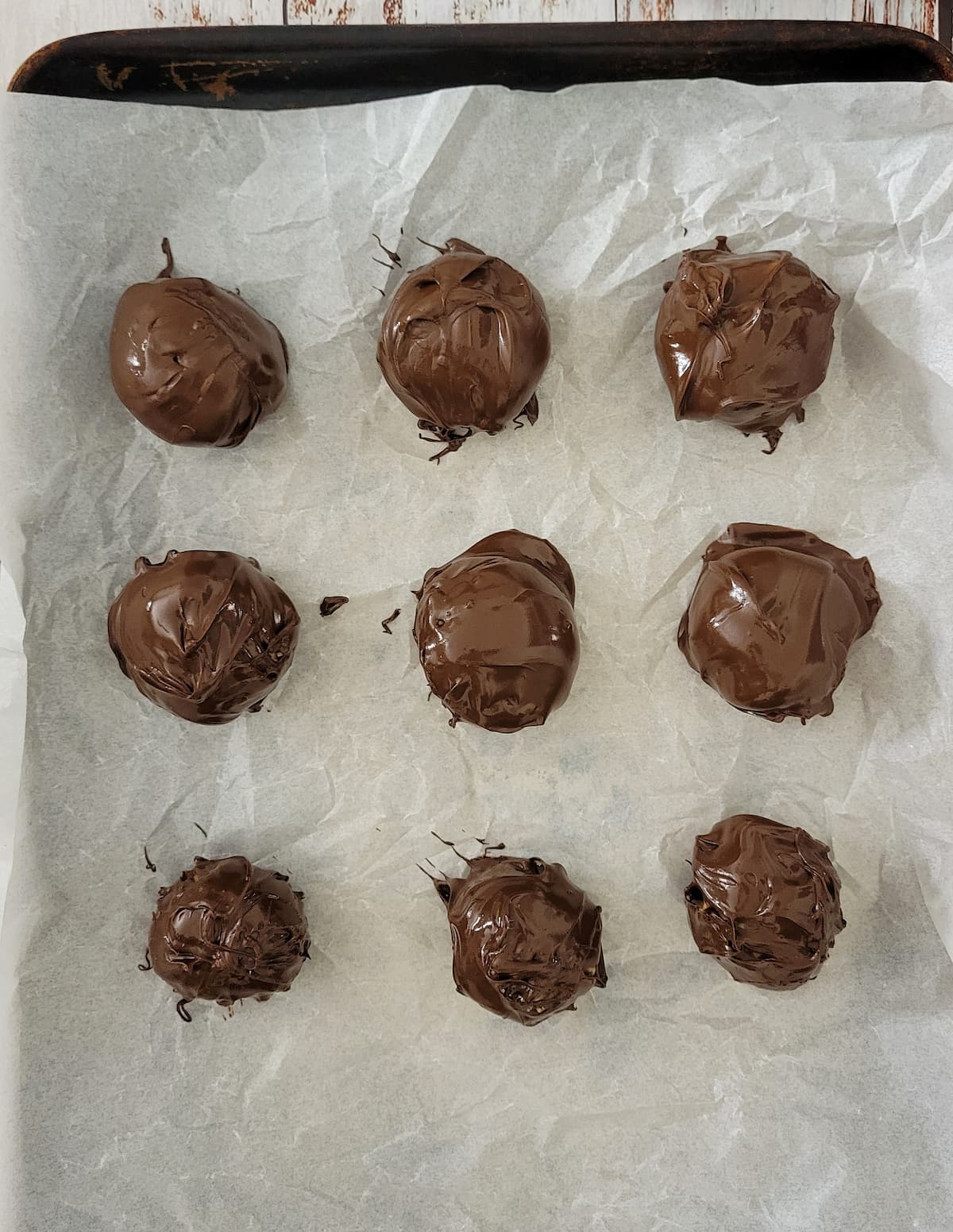 chocolate balls on a parchment lined baking sheet