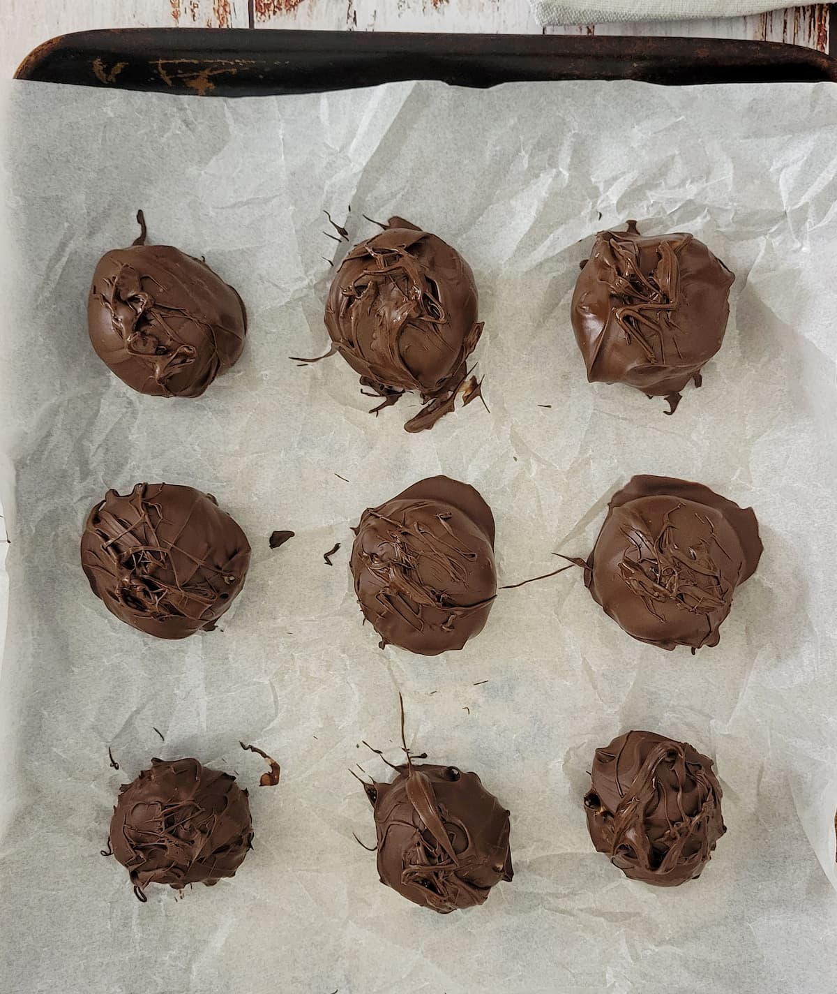 chocolate balls on a parchment lined baking sheet