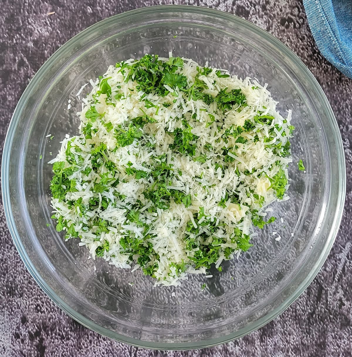 freshly grated parmesan cheese and chopped fresh parsley mixed in a bowl