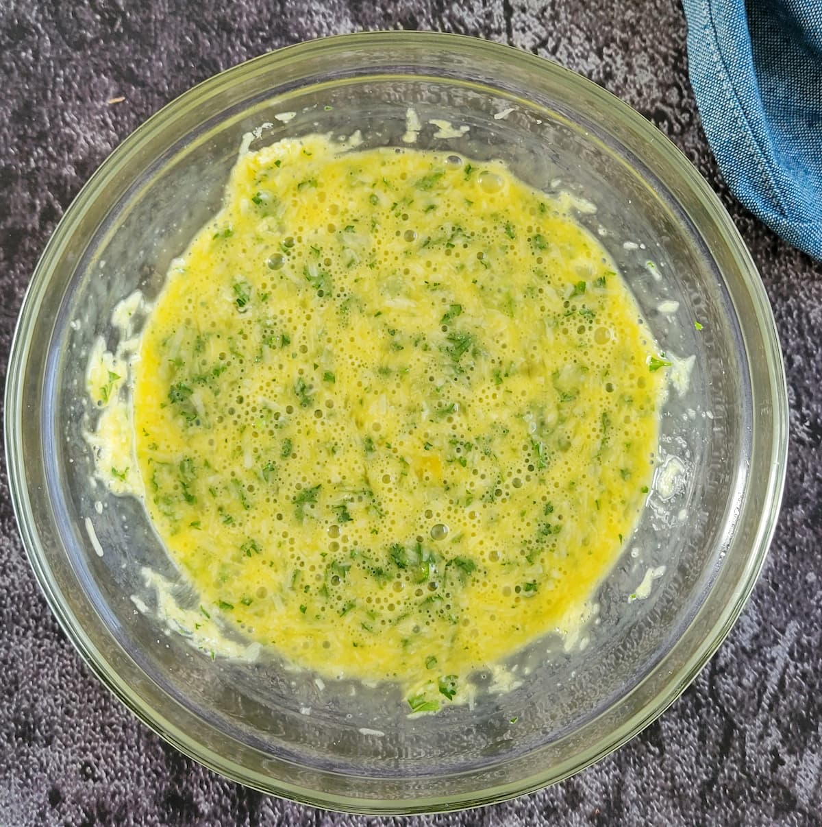 beaten eggs in a bowl with parsley