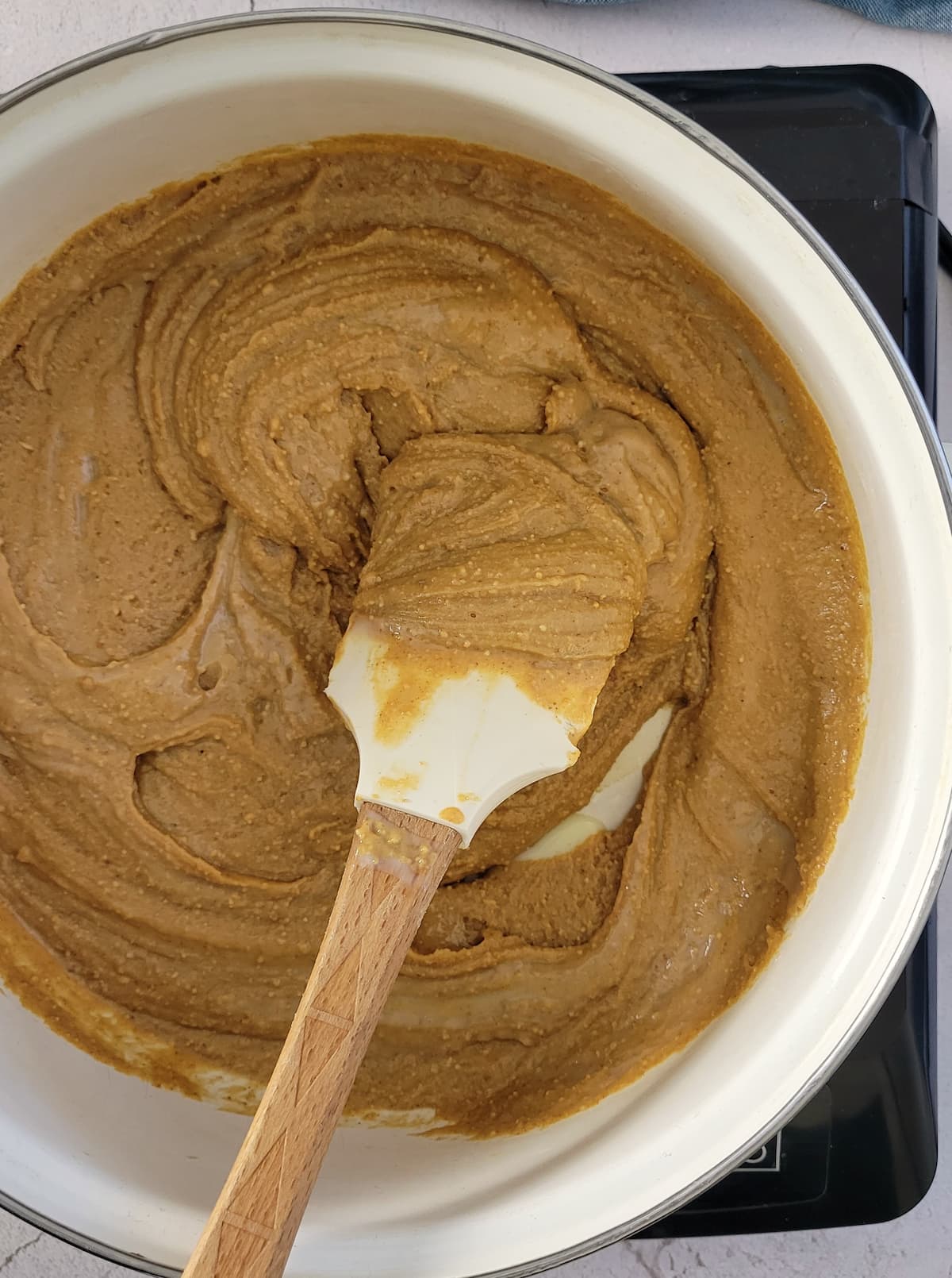 wooden spatula in a pot of peanut butter on a burner