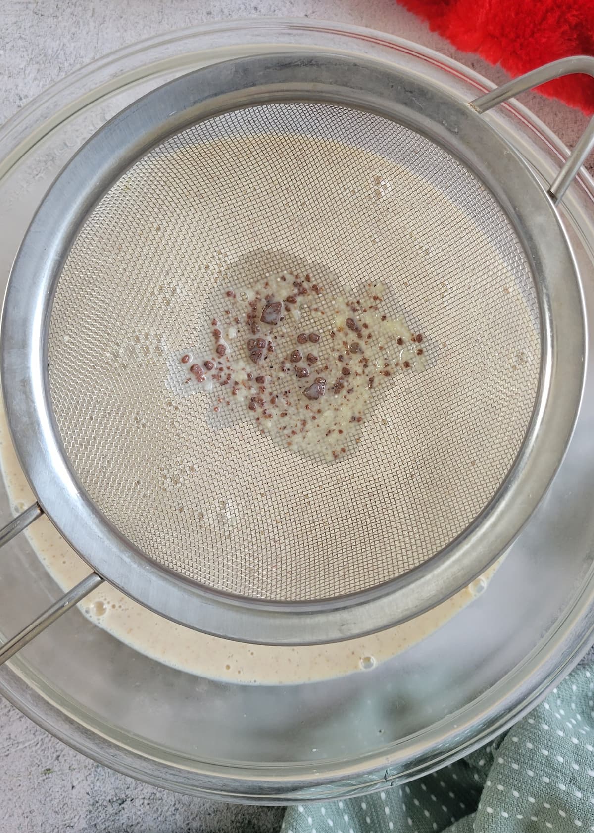 fine mesh strainer straining homemade eggnog into a bowl