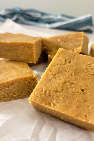 peanut butter fudge stacked on a piece of parchment paper