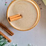 glass of eggnog with a cinnamon stick and rim