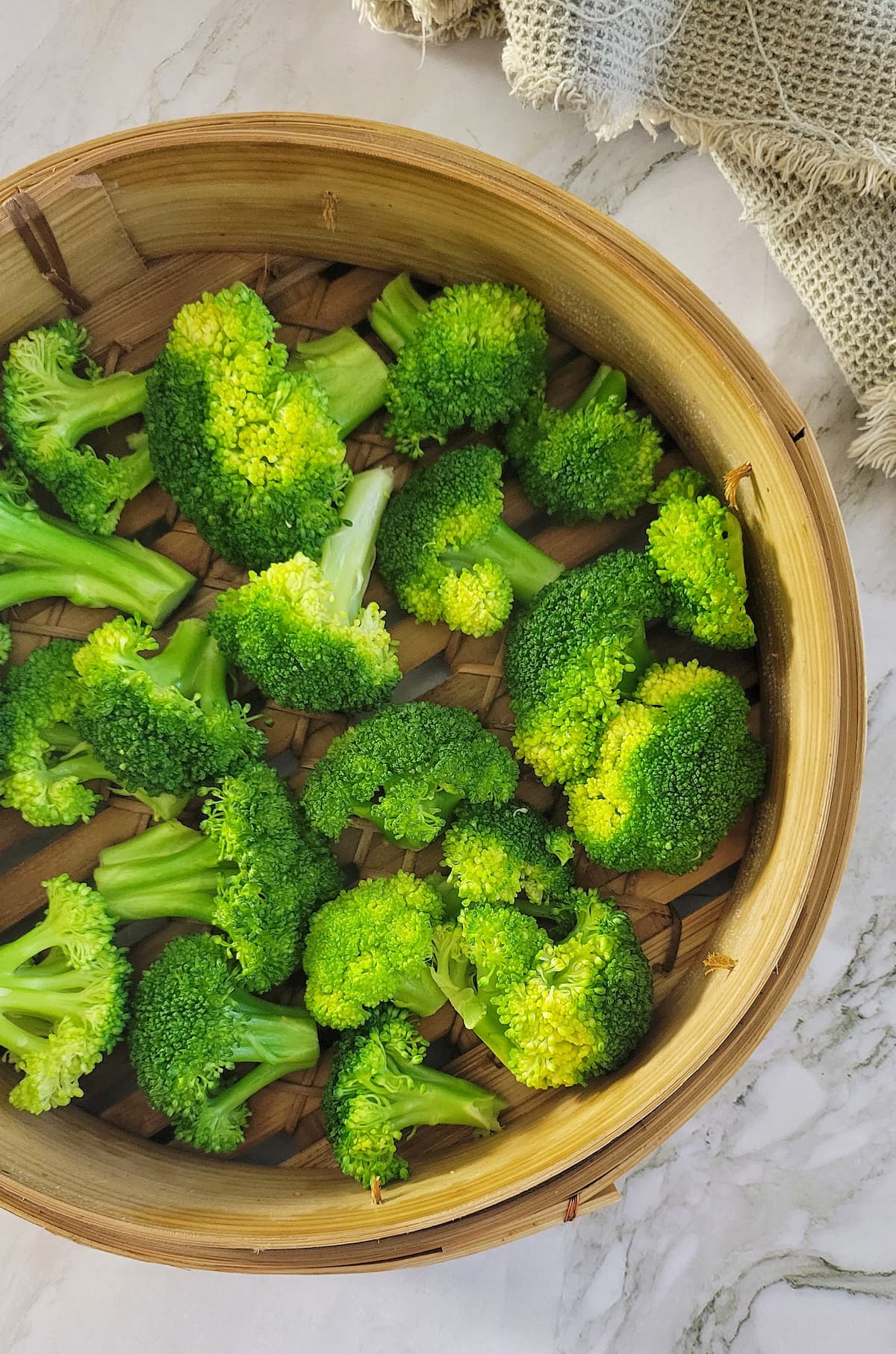 broccoli florets in a bamboo steamer basket