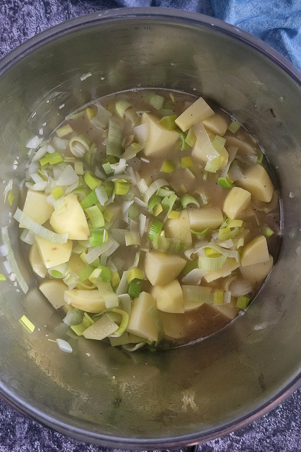 diced potatoes and leeks in broth in a pot