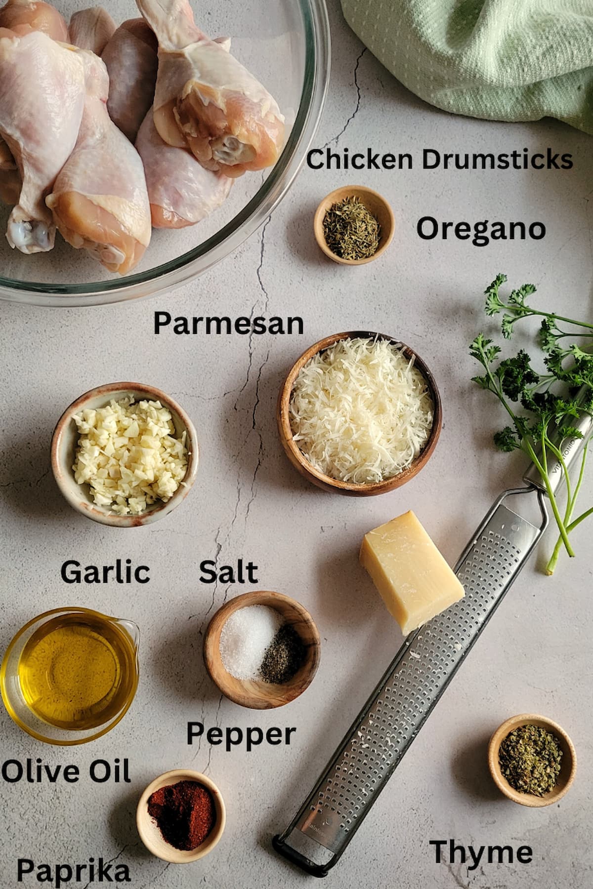 ingredients for drumstick recipe - chicken drumsticks, paprika, oregano, thyme, salt, pepper, garlic, parmesan, garlic, olive oil