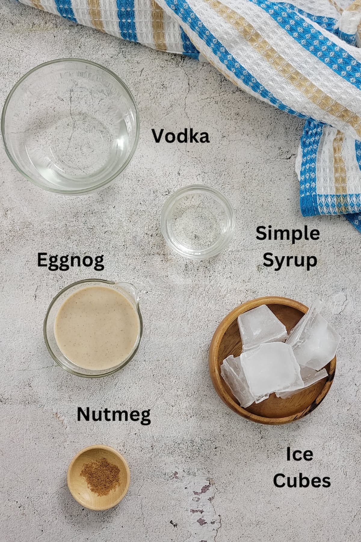 ingredients to make a martini with eggnog - vodka, eggnog, simple syrup, ice cubes, nutmeg