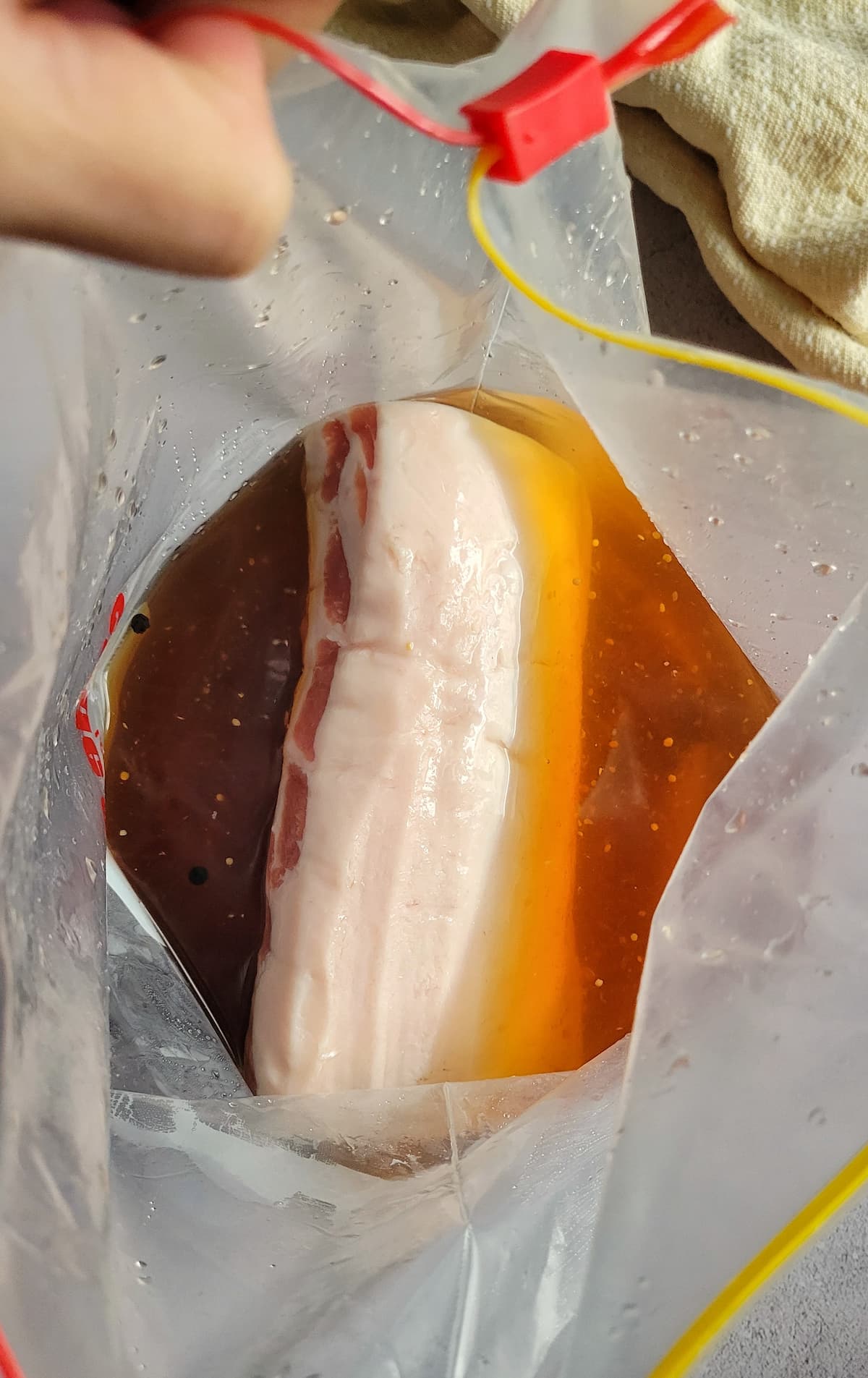 raw whole pork loin in brine in a ziploc bag