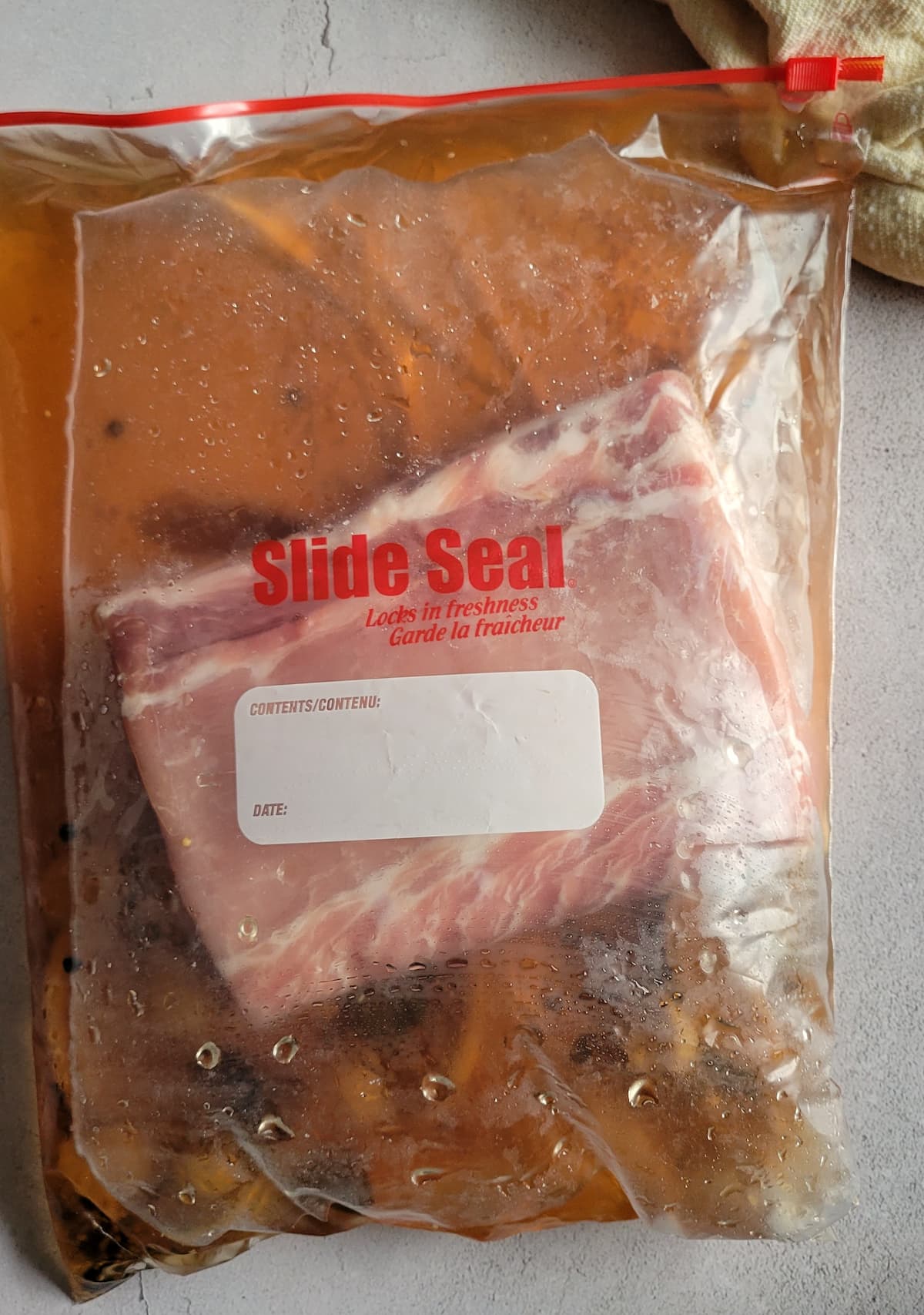 raw whole pork loin in brine in a ziploc bag